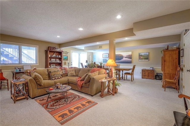 living room featuring a wealth of natural light, recessed lighting, light colored carpet, and a textured ceiling