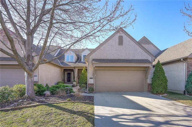 traditional-style home featuring concrete driveway, a garage, and stucco siding