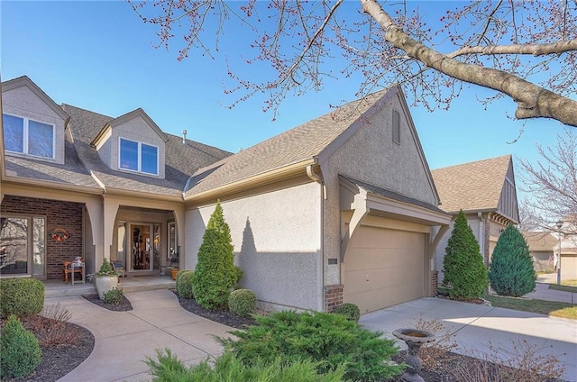 view of front facade with a porch, an attached garage, stucco siding, concrete driveway, and brick siding