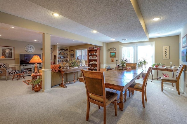 dining space with carpet, a wealth of natural light, and a textured ceiling