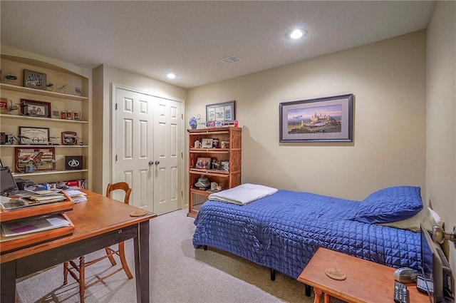 carpeted bedroom featuring a closet, visible vents, recessed lighting, and a textured ceiling