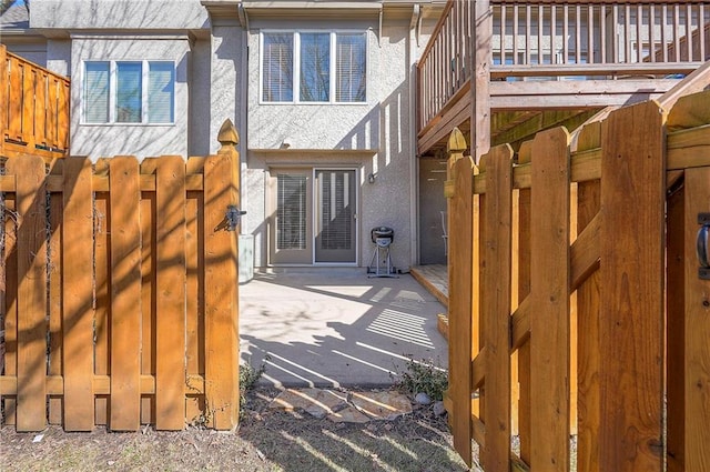 property entrance featuring stucco siding, a patio, and fence