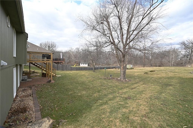 view of yard with a deck, stairs, and fence