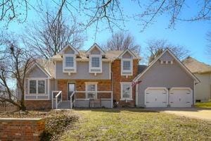 traditional-style home with a front yard, an attached garage, and driveway