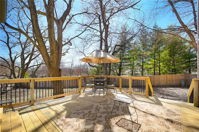 deck with outdoor dining area and fence