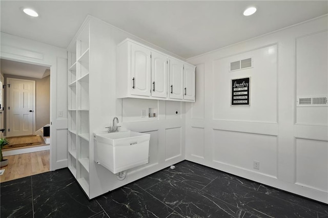 washroom featuring washer hookup, recessed lighting, a decorative wall, marble finish floor, and hookup for an electric dryer