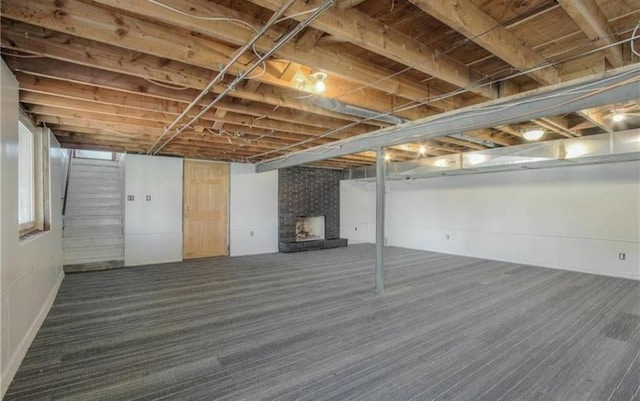 finished basement featuring carpet and a large fireplace