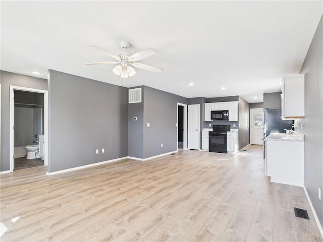 unfurnished living room featuring visible vents, baseboards, light wood-style flooring, and a ceiling fan