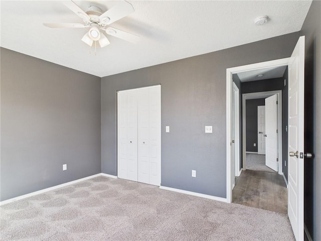 unfurnished bedroom with a closet, a ceiling fan, baseboards, and carpet floors