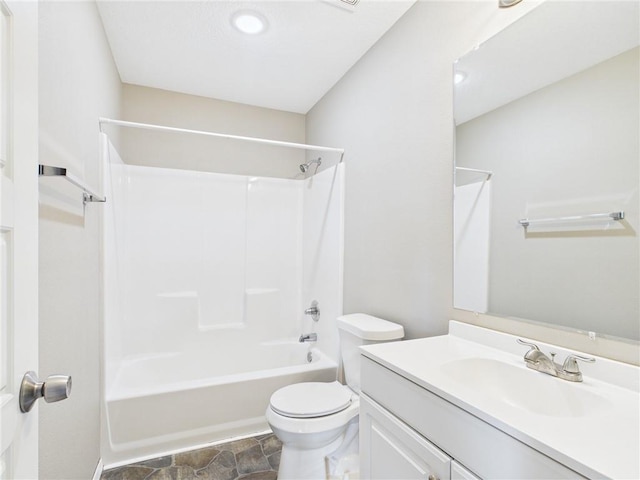 full bath featuring shower / bath combination, stone finish flooring, toilet, and vanity