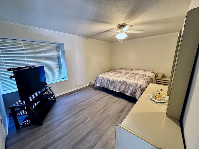 bedroom with ceiling fan, baseboards, ornamental molding, wood finished floors, and a textured ceiling