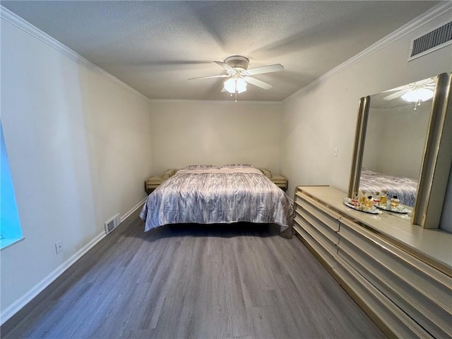 unfurnished bedroom featuring visible vents, a textured ceiling, wood finished floors, and crown molding