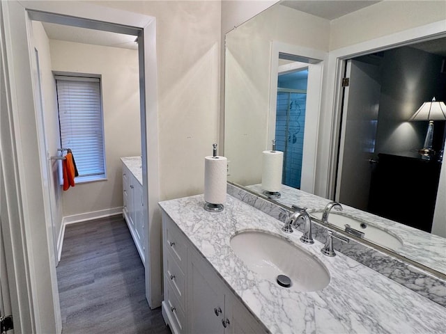 bathroom with vanity, baseboards, and wood finished floors