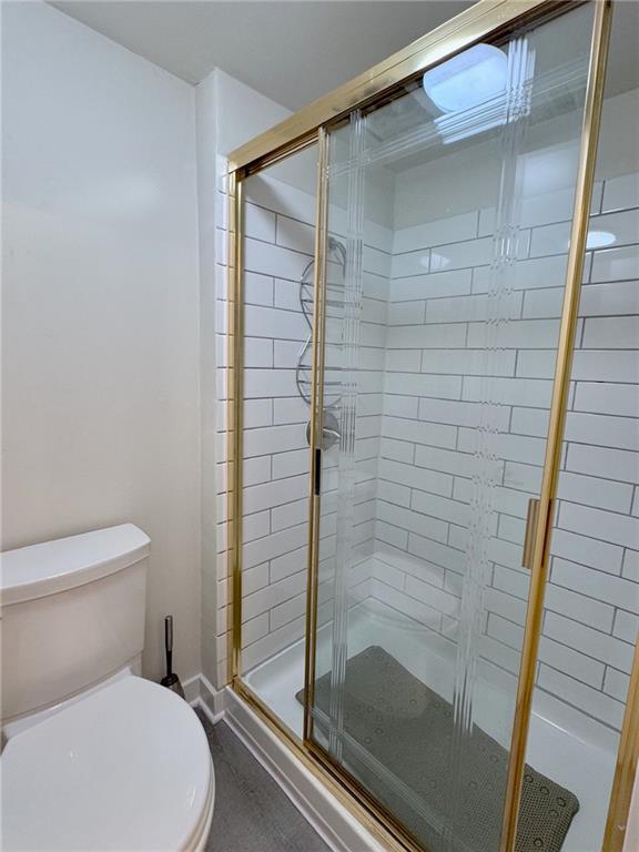 full bath with a shower stall and toilet