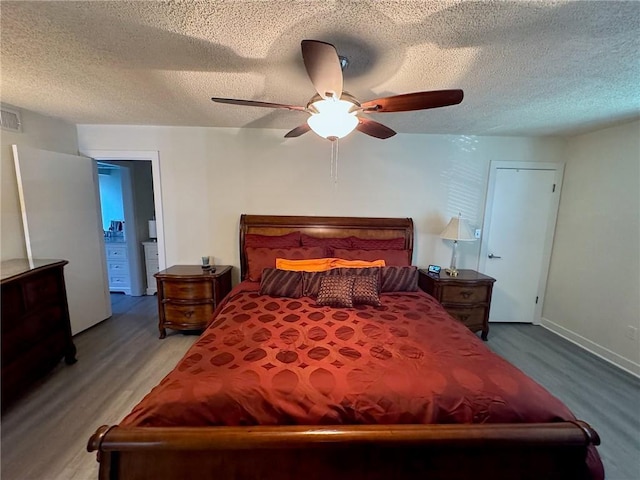 bedroom featuring visible vents, a textured ceiling, wood finished floors, and a ceiling fan