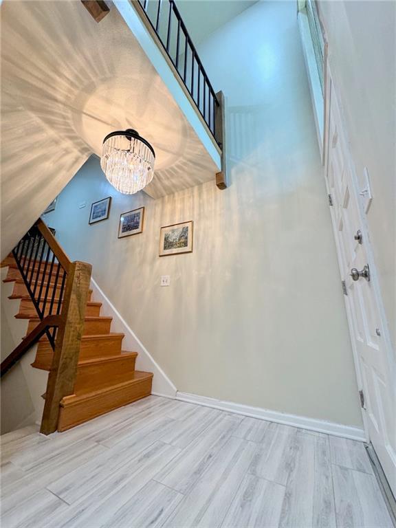 staircase featuring baseboards, lofted ceiling, and wood finished floors