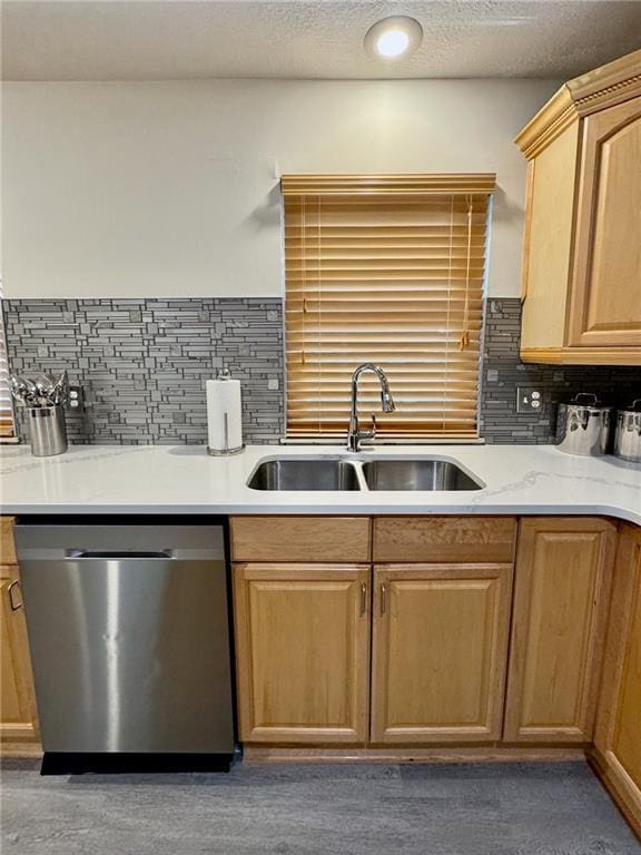 kitchen featuring backsplash, light countertops, stainless steel dishwasher, a textured ceiling, and a sink