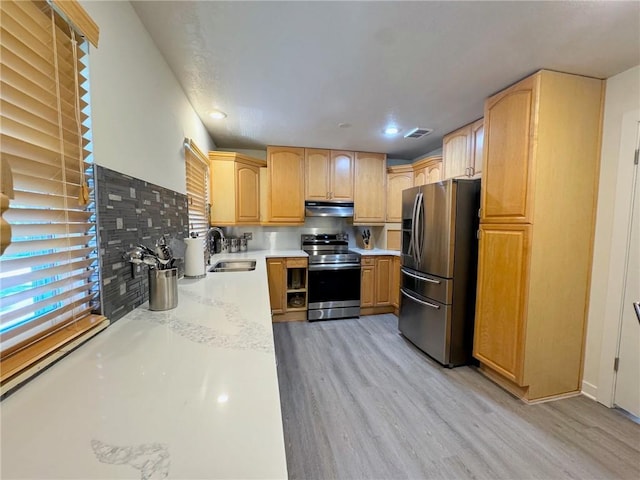 kitchen with visible vents, light wood-style flooring, a sink, under cabinet range hood, and appliances with stainless steel finishes