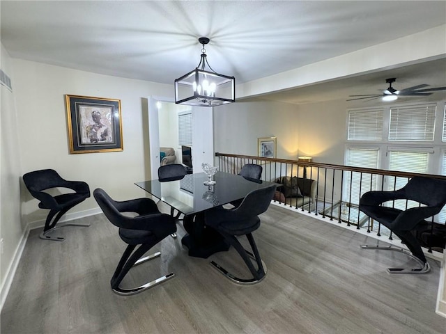 dining space with a chandelier, baseboards, and wood finished floors