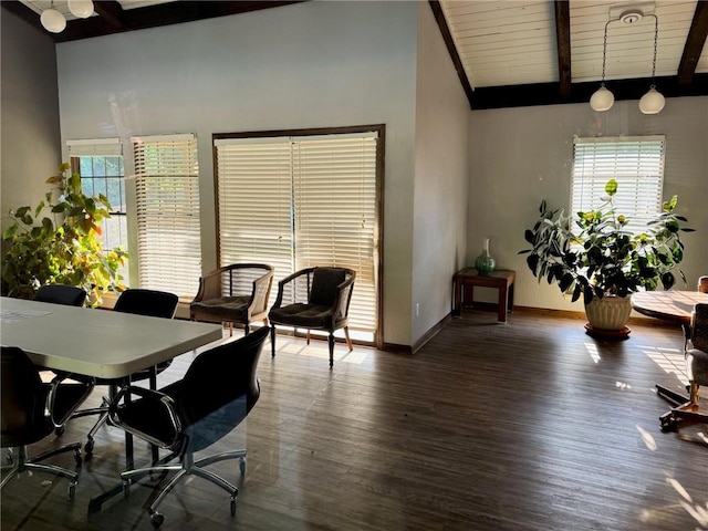 dining space featuring lofted ceiling with beams, baseboards, and wood finished floors