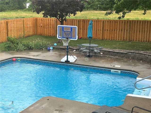 view of swimming pool featuring a patio area, a fenced in pool, a fenced backyard, and a lawn