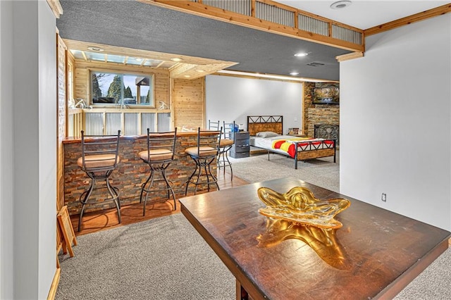 dining space featuring indoor wet bar, carpet flooring, a fireplace, and recessed lighting