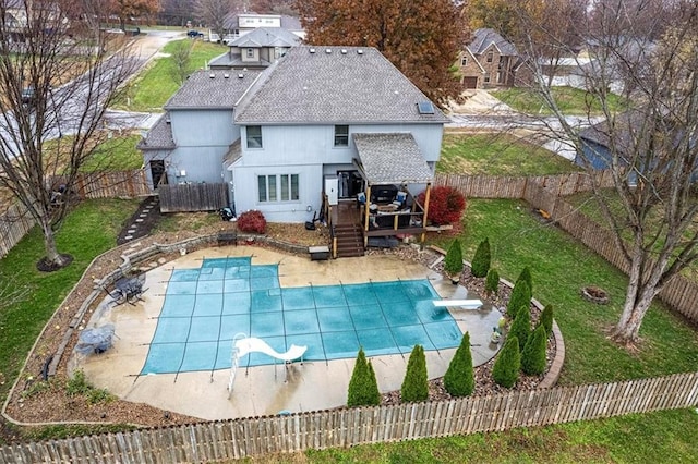 exterior space with a patio area, a lawn, a fenced backyard, and a diving board