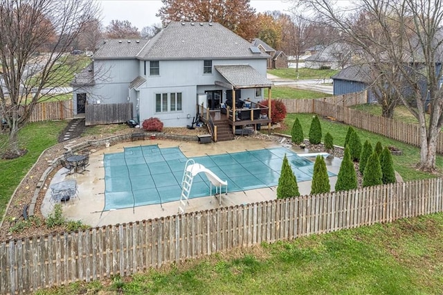 view of swimming pool featuring a patio area, a fenced backyard, a lawn, and a wooden deck