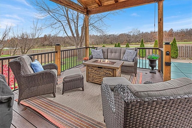 wooden deck featuring an outdoor living space with a fire pit