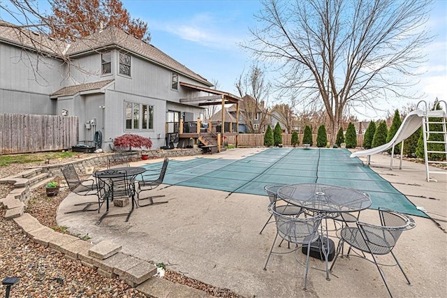 view of pool with a fenced in pool, a water slide, a patio, and fence