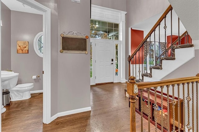 entrance foyer with stairs, wood finished floors, and baseboards