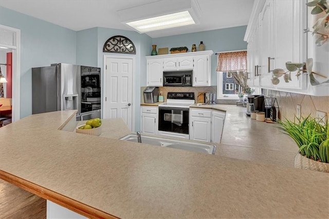 kitchen featuring electric range, a sink, stainless steel refrigerator with ice dispenser, black microwave, and backsplash