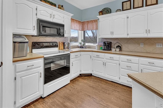 kitchen with light countertops, light wood-style flooring, black microwave, and electric stove