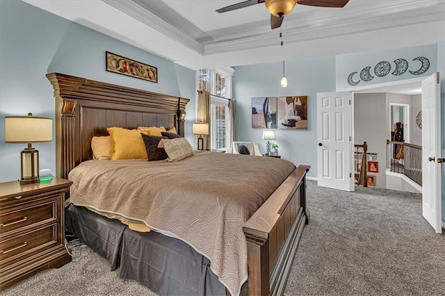 bedroom featuring crown molding, carpet flooring, a tray ceiling, and ceiling fan