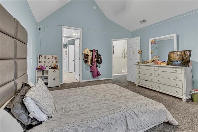 bedroom with baseboards, visible vents, carpet floors, high vaulted ceiling, and ensuite bath