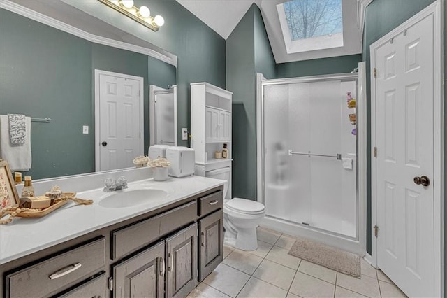 bathroom featuring vanity, a skylight, tile patterned flooring, a shower stall, and toilet