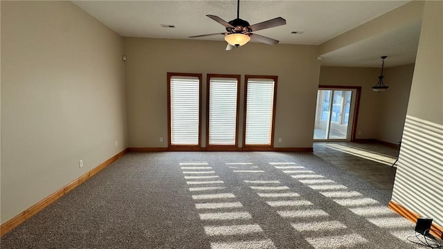 spare room featuring visible vents, carpet, baseboards, and ceiling fan