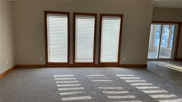 carpeted empty room with baseboards