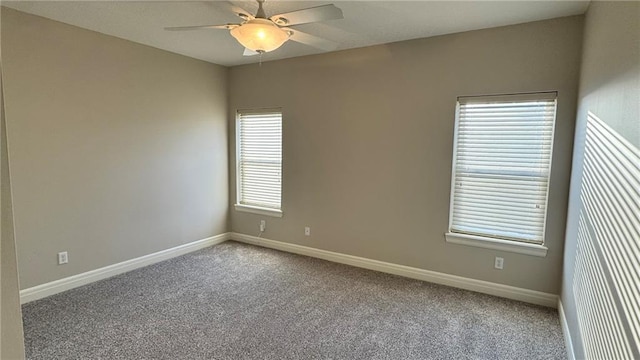 carpeted spare room featuring baseboards and a ceiling fan