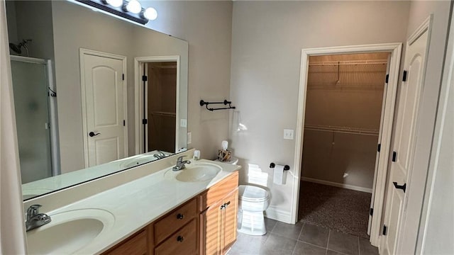 bathroom with a sink, double vanity, a shower stall, and tile patterned flooring