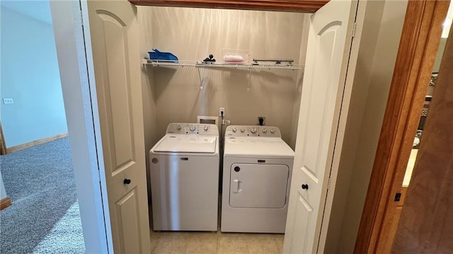 clothes washing area with laundry area, light colored carpet, baseboards, and separate washer and dryer