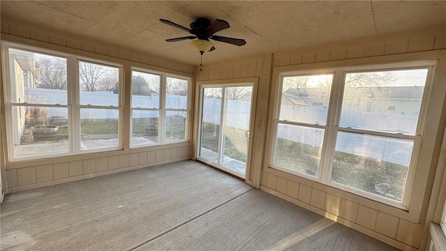 unfurnished sunroom featuring ceiling fan