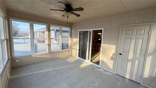 unfurnished sunroom featuring a ceiling fan