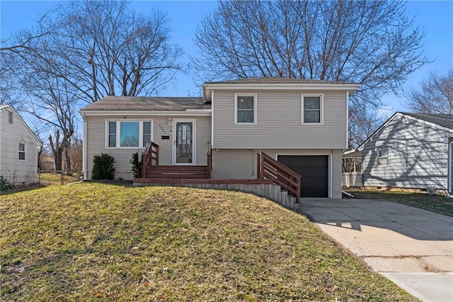 split level home with a front lawn, an attached garage, and driveway