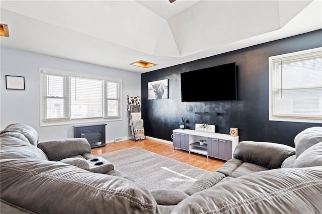 living area featuring baseboards, attic access, wood finished floors, and an accent wall