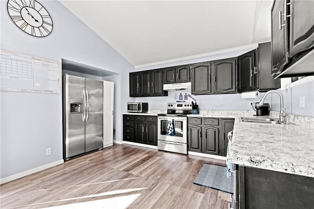 kitchen with lofted ceiling, a sink, under cabinet range hood, appliances with stainless steel finishes, and light wood-type flooring