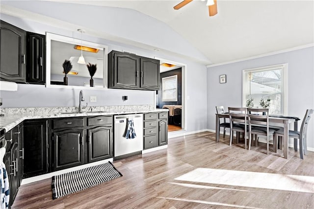 kitchen featuring stainless steel dishwasher, vaulted ceiling, light wood-style floors, and a sink