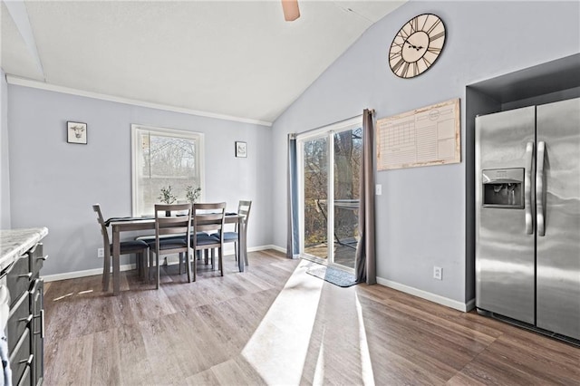 dining room with baseboards, lofted ceiling, and wood finished floors