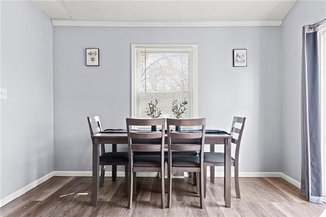 dining area with crown molding, baseboards, and wood finished floors