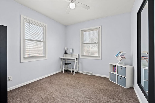 carpeted office space featuring visible vents, a ceiling fan, and baseboards